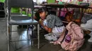 Para siswa saat ambil bagian dalam latihan gempa bumi dalam acara simulasi evakuasi mandiri dalam rangka peringatan bulan pengurangan risiko bencana di Banda Aceh, Rabu (9/10/2024). (CHAIDEER MAHYUDDIN/AFP)