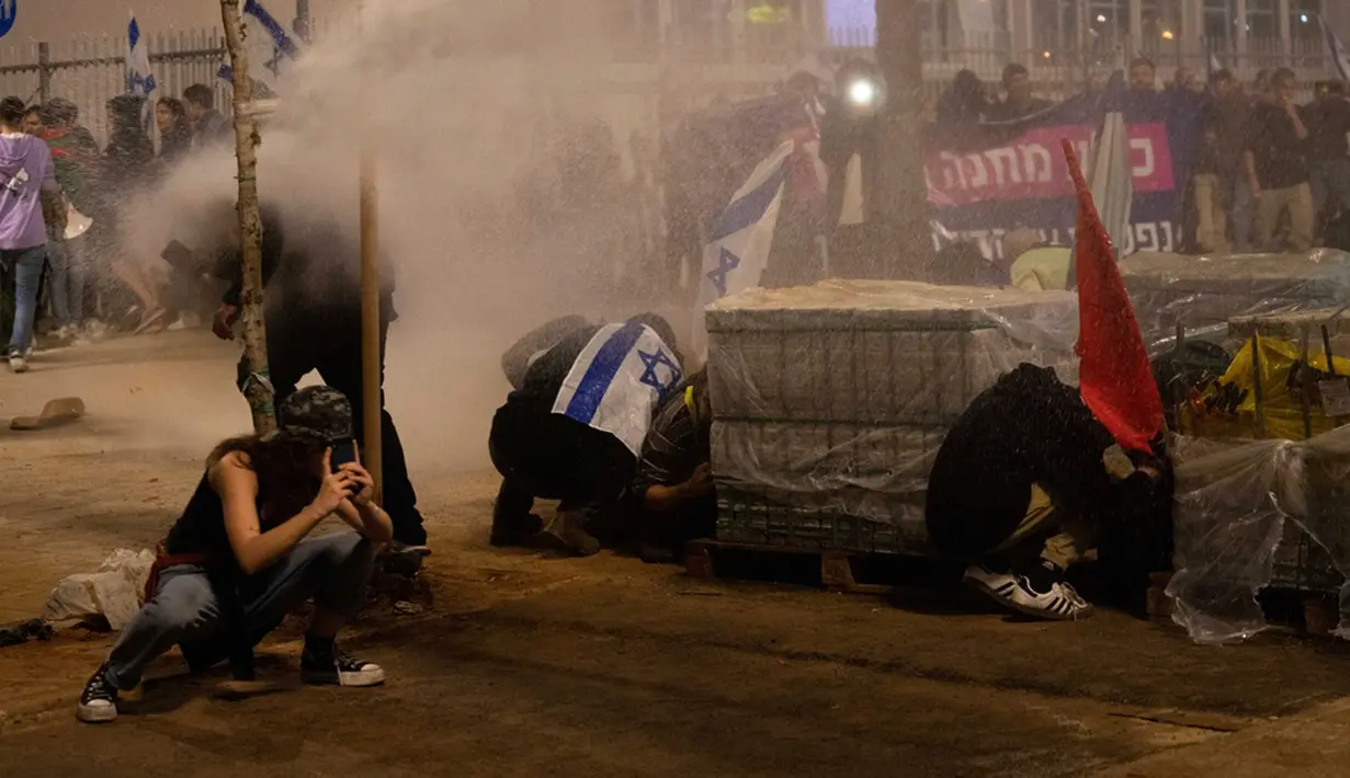 Pengumuman Netanyahu datang setelah puluhan ribu masyarakat Israel berdemonstrasi di luar parlemen dan serikat buruh terbesar di negara itu melancarkan aksi mogok nasional. (AP Photo/Oded Balilty)