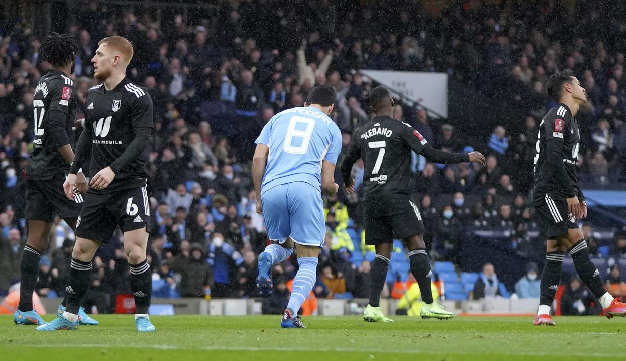 Hanya butuh dua menit, Manchester City berhasil menyamakan skor 1-1. Gol dicetak via sontekan Ilkay Guendogan (tengah) yang tidak mampu dibendung kiper Fulham Paulo Gazzaniga usai menerima umpan Riyad Mahrez. (AP/Jon Super)