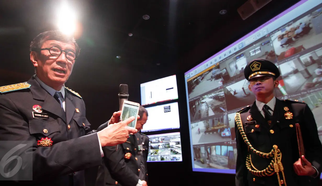 Menkumham Yasonna H Laoly menunjukkan layar telepon pintarnya yang terkoneksi langsung dengan kamera CCTV di sejumlah Lapas seusai acara peresmian Control Room Kami Pasti di Gedung Kemenkumham, Jakarta, Jumat (30/10). (Liputan6.com/Helmi Afandi)