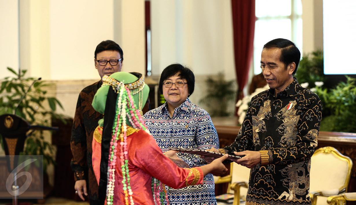 Presiden Joko Widodo menyerahkan surat keputusan pengakuan  Hutan Adat kepada perwakilan pemangku hutan adat saat pencanangan pengakuan hutan adat di Istana Negara, Jakarta, Jumat (30/12). (Liputan6.com/Faizal Fanani)