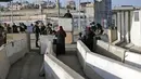 Anggota pasukan keamanan Israel berjaga-jaga di pos pemeriksaan Qalandia antara kota Ramallah Tepi Barat dan Yerusalem, ketika orang-orang Palestina menyeberang untuk menghadiri sholat Jumat kedua bulan Ramadhan di masjid Al-Aqsa, Jumat (23/4/2021). (ABBAS MOMANI / AFP)