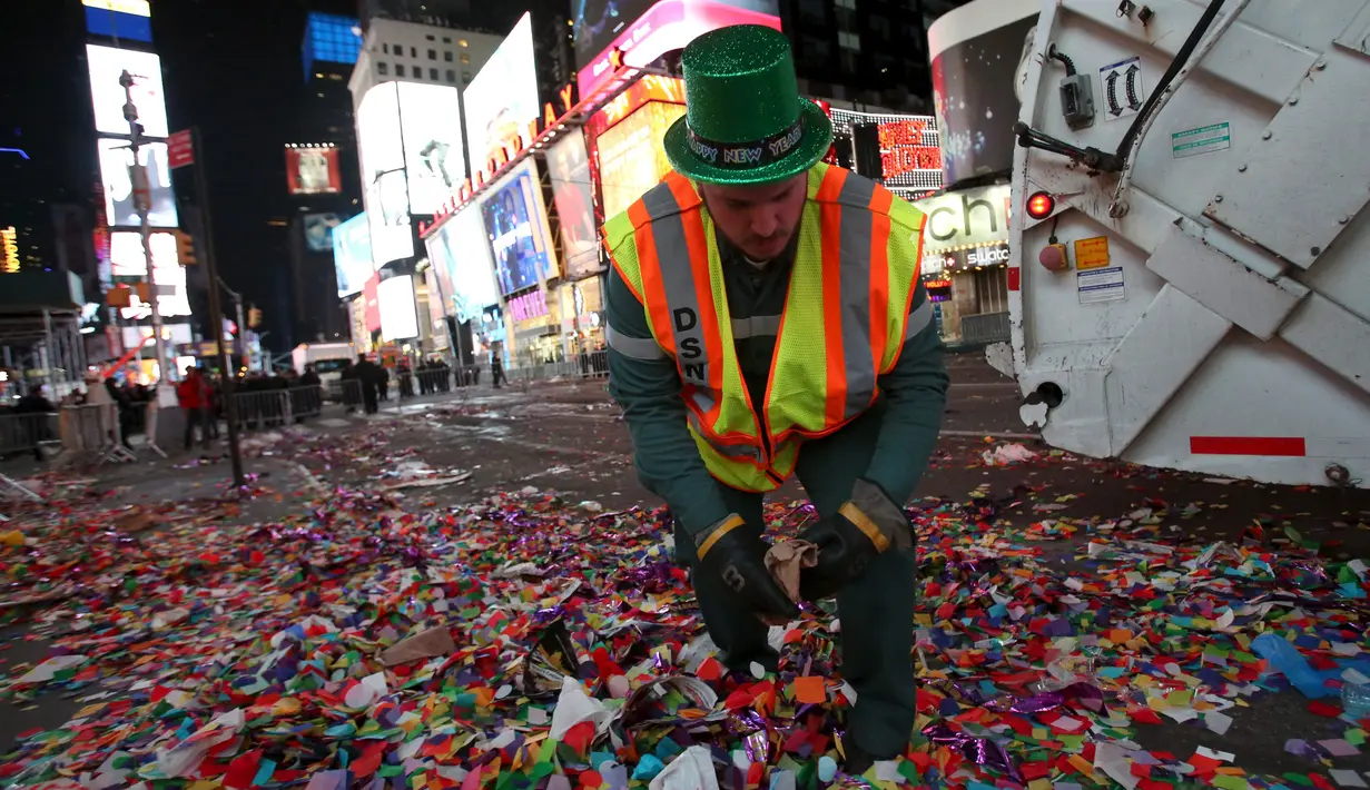 Petugas kebersihan membersihkan sampah yang berserakan di jalan usai perayaan tahun baru 2016 di Times Square di Manhattan borough, New York, USA (1/1/2016). (REUTERS/Andrew Kelly)