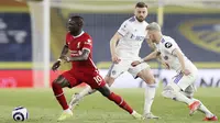 Striker Liverpool,  Sadio Mane, berusaha melewati pemain Leeds United, Ezgjan Alioski, pada laga Liga Inggris di Stadion Elland Road, Senin (19/4/2021). Kedua tim bermain imbang 1-1. (Clive Brunskill/Pool via AP)