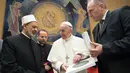 Pemimpin umat Katolik dunia, Paus Fransiskus dan Imam Besar Masjid Al-Azhar, Ahmed al-Tayeb bertukar hadiah pada sebuah pertemuan pribadi  di Vatikan, Selasa (7/11). (L'Osservatore Romano/Pool via AP)