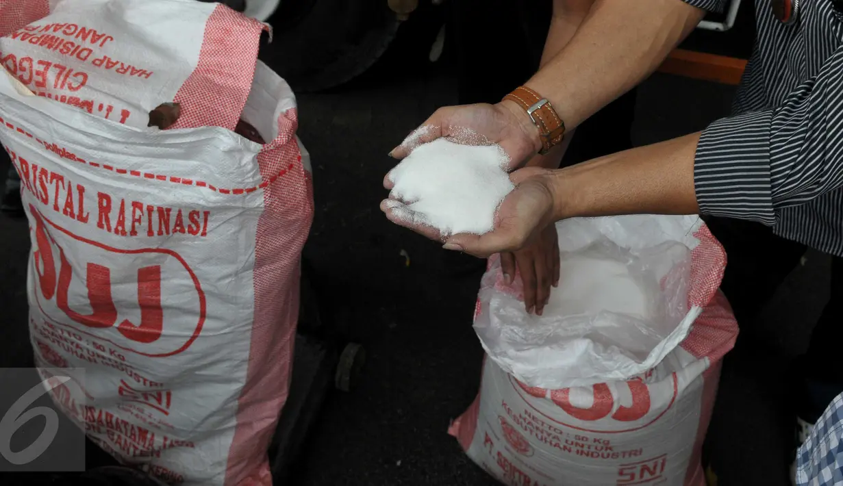 Petugas memperlihatkan gula pasir yang berhasil diamankan, Jakarta, Rabu (24/6/2015). Sebanyak 60 ton gula pasir dan tiga orang tersangka berhasil diamankan Polda Metro Jaya di kawasan Tangerang. (Liputan6.com/Johan Tallo)