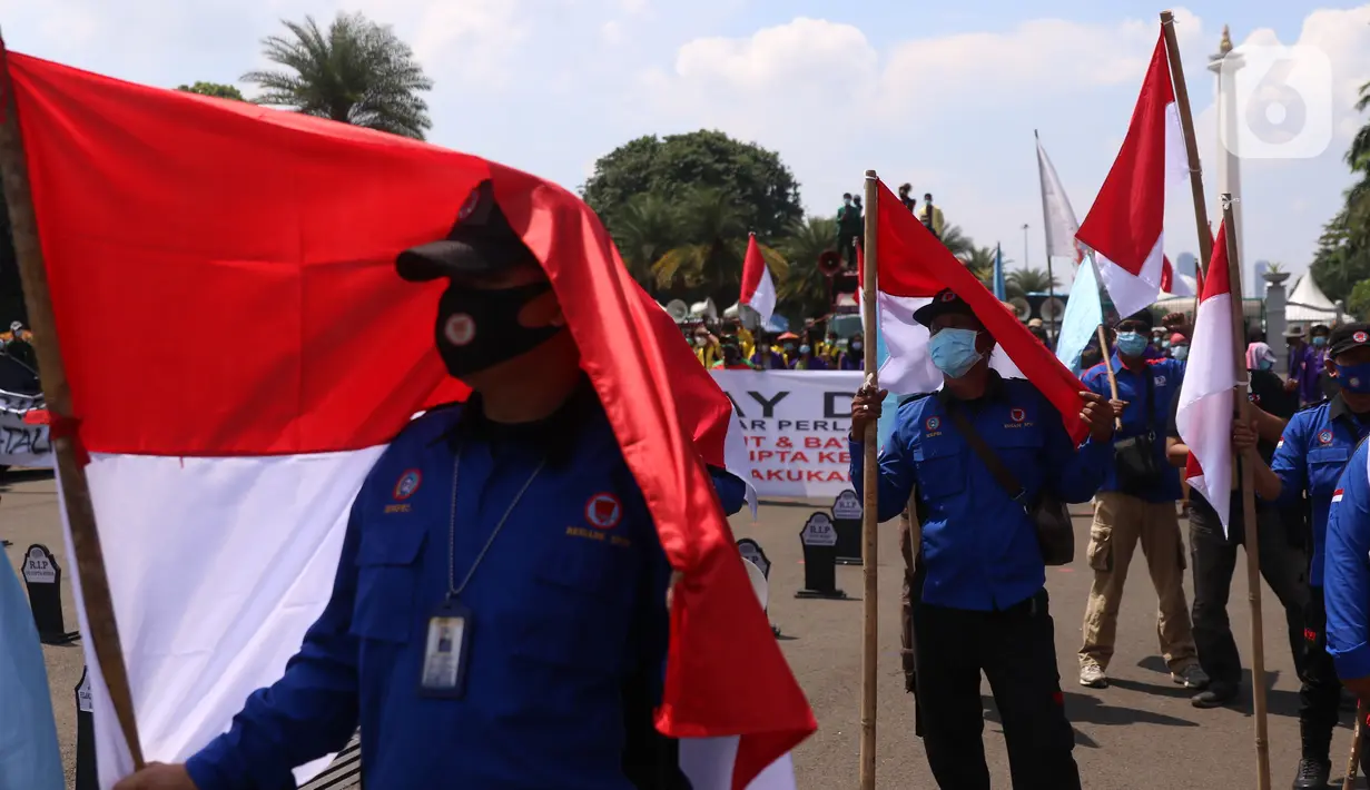 Para buruh dari berbagai aliansi membawa berbagai spanduk maupun bendera saat aksi memperingati Hari Buruh Internasional atau May Day di Jakarta, Sabtu (1/5/2021). Mereka meminta pemerintah untuk mencabut Omnibus Law dan memberlakukan upah minimum sektoral (UMSK) 2021. (Liputan6.com/Angga Yuniar)