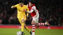 Bek Arsenal, Takehiro Tomiyasu berusaha merebut bola dari gelandang Liverpool Curtis Jones pada pertandingan leg kedua semifinal Piala Liga Inggris di Stadion Emirates di London, Jumat (21/1/2022). Dengan kemenangan ini Liverpool berhasil melaju ke final. (AP Photo/Matt Dunham)