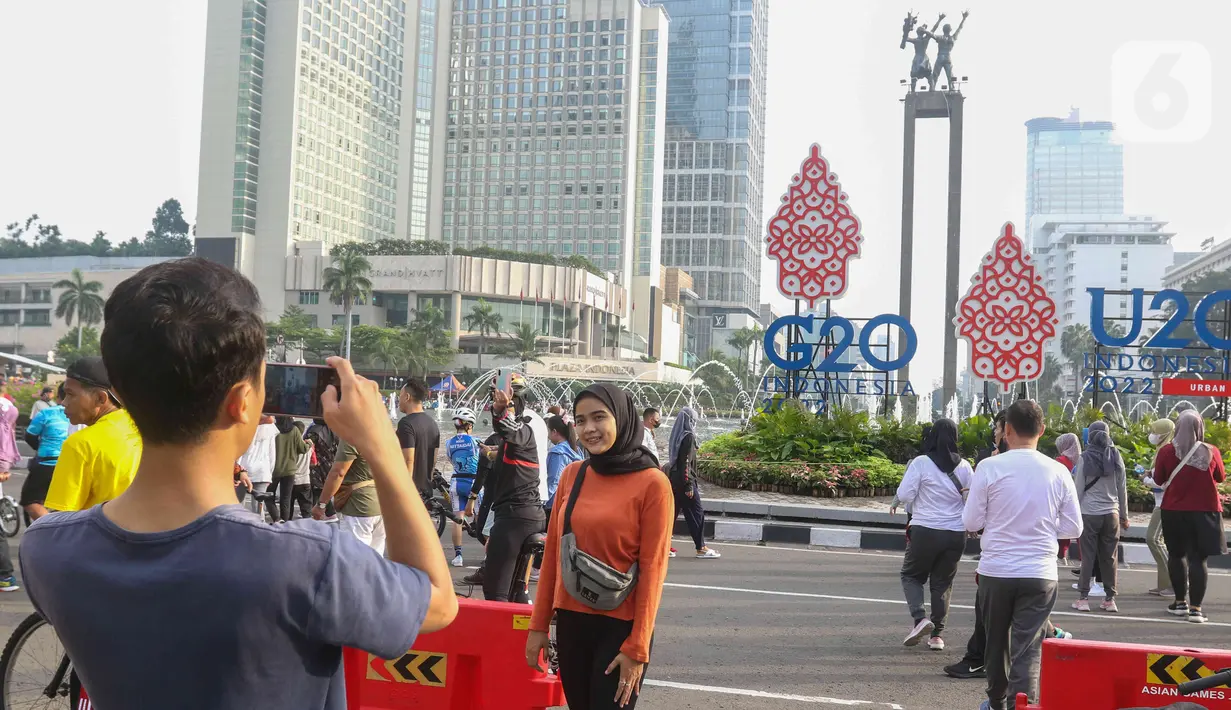 Warga foto di kawasan bundaran HI, Jakarta, Minggu (12/6/2022). Car Free Day di kawasan Sudirman-Thamrin dimanfaatkan warga untuk berolah raga dan ber foto-foto. (Liputan6.com/Herman Zakharia)