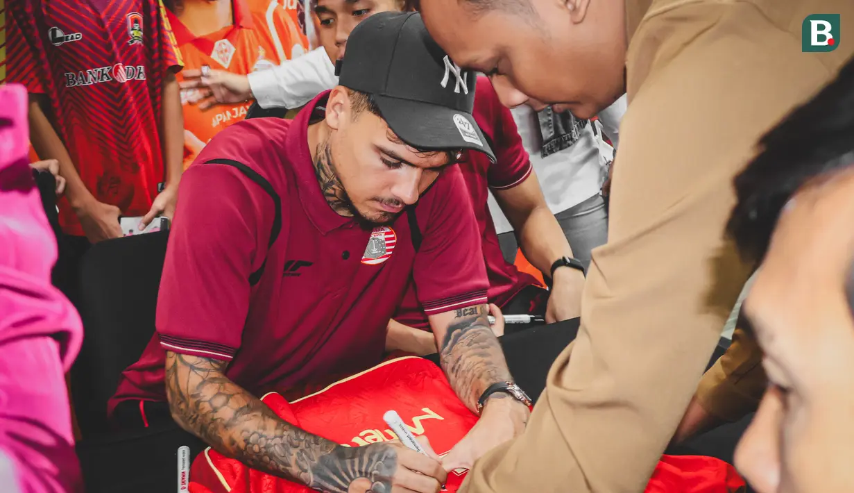 Shayne Pattynama menandatangani jersey milik Jakmania dalam acara meet & greet di Kantor Pusat Bank Jakarta pada Rabu (18/2/2025). (Bola.com/Nur Iman Ali)