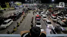 Seorang anak memperhatikan antrean mobil yang akan masuk ke dalam kapal penyeberangan di Pelabuhan Merak, Kota Cilegon, Banten, Jumat (28/3/2025) dini hari. (Liputan6.com/Herman Zakharia)