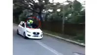 Seroang polisi Lalu Lintas Polres Gowa bertahan di atas kaca mobil yang melaju, usah melakukan pemeriksaan. (Instagram)