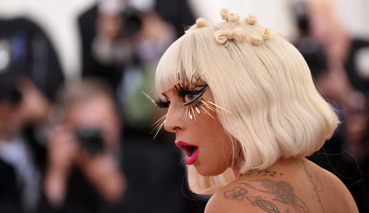 Lady Gaga mengenakan bulu mata emas saat menghadiri Met Gala 2019 yang digelar di The Metropolitan Museum of Art, New York, Amerika Serikat, Sanin (6/5/2019). Lady gaga mengenakan empat busana yang heboh dan meriah saat menghadiri Met Gala 2019. (Photo by Evan Agostini/Invision/AP)