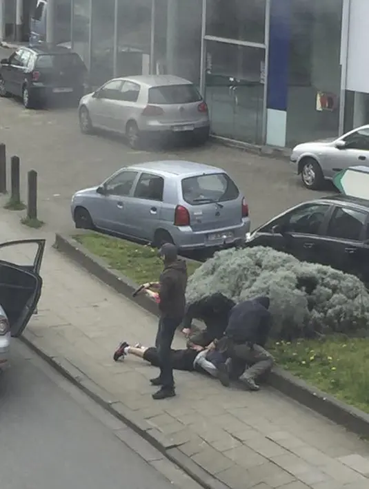Aksi Polisi Belgia saat menangkap tersangka penyerangan di Paris Mohamed Abrini di Brussel, Belgia, Jumat (8/4). Buronan terkait kasus bom di Bandara Zaventem merupakan dalang dari penyerangan di Paris pada 2015 lalu. (REUTERS/Sebastien Dana-Kamran)
