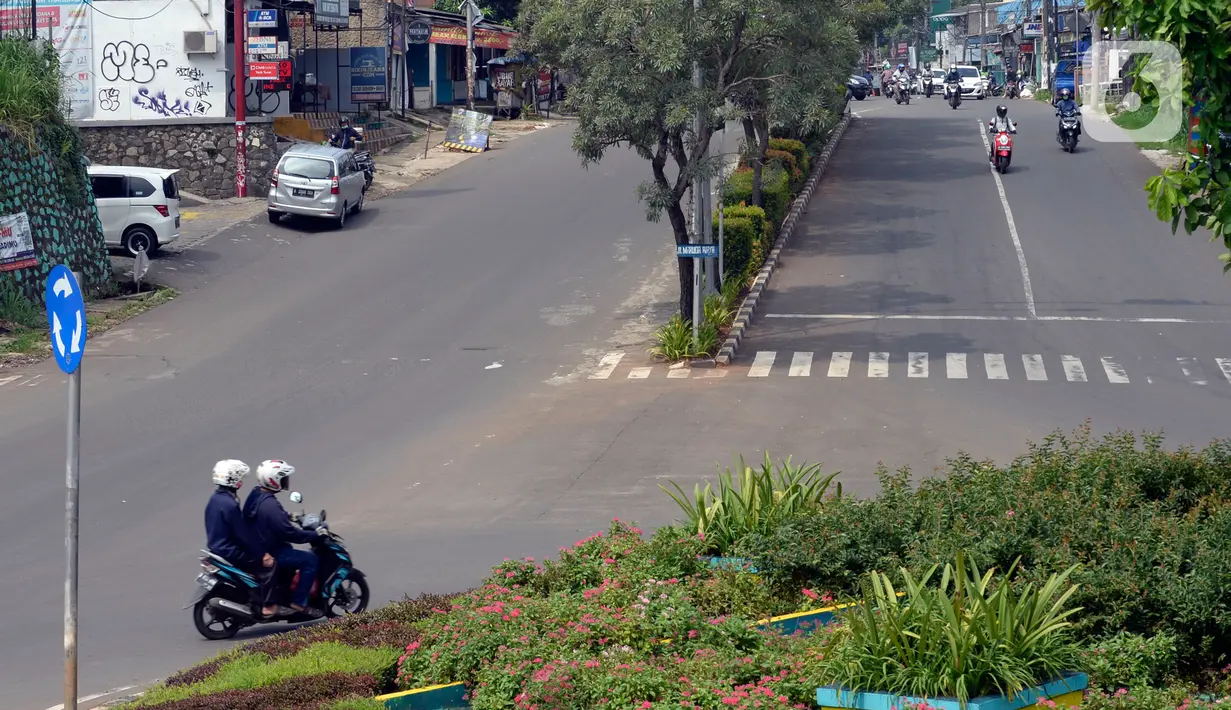 Aktivitas lalulalang kendaraan roda dua dan empat terlihat lengang pada hari ketiga penerapan Pembatasan Sosial Berskala Besar (PSBB) di Bundaran Ciater, Tangerang Selatan, Banten, Senin (20/04/2020). (merdeka.com/Dwi Narwoko)