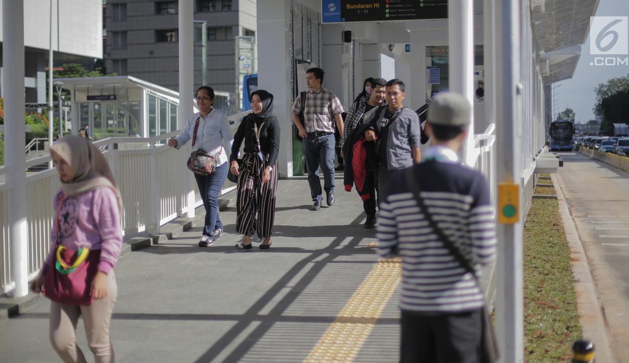 Aktivitas penumpang di Halte Bus Transjakarta Bundaran Hotel Indonesia (HI), Jakarta, Senin (25/3). Halte Bundaran HI menjadi halte Transjakarta pertama yang terintegrasi fisik secara langsung dengan stasiun Moda Raya Terpadu (MRT). (Liputan6.com/Faizal Fanani)
