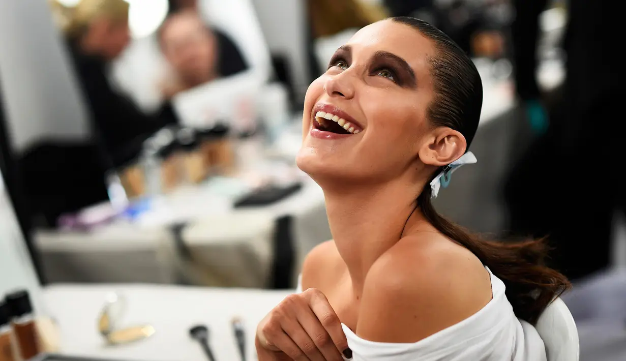 Bella Hadid tertawa usai dipakaikan make-up di belakang panggung Blenheim Palace pada peragaan busana kolehsi Dior, Cruise 2017 di Woodstock, Inggris, 31 Mei 2016. (REUTERS/Dylan Martinez)
