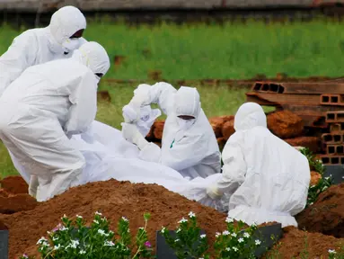 Paramedis memakai pakaian pelindung saat menguburkan jenazah yang tewas akibat virus Nipah di Kozhikode, Kerala, India Selatan, Kamis (24/5). Langkah tersebut dilakukan untuk mencegah penularan virus Nipah. (AP Photo/K.Shijith)