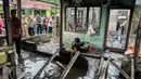 Warga berkerumun di sekitar lokasi kebakaran pabrik korek gas di Binjai, Langkat, Sumatera Utara, (21/6/2019). Korban tewas dalam kebakaran tersebut terdiri dari ibu rumah tangga dan anak-anak. (Ivan Damanik/AFP)