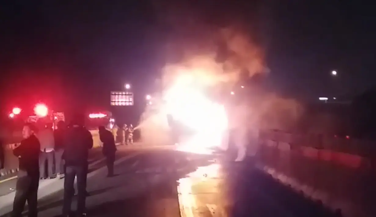 Kobaran api terlihat membakar badan bus berpenumpang sekelompok wisatawan lokal di Gyeongbu Expressway, tenggara Kota Ulsan, Korea Selatan, Kamis (13/10) malam. Sedikitnya 10 orang tewas dan tujuh lainnya luka berat akibat insiden itu. (Yonhap/AFP)