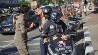 Petugas Satpol PP memeriksa pengendara motor saat operasi kepatuhan disiplin masker di kawasan Waduk Sunter, Jakarta, Selasa (8/9/2020). Operasi yang rutin diadakan setiap hari tersebut dilakukan guna menekan penyebaran COVID-19. (Liputan6.com/Immanuel Antonius)