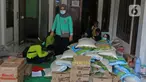 Warga mengemas bantuan bahan pokok untuk pasien positif Covid-19 di RT03/RW03, Kelurahan Cilangkap, Jakarta, Jumat (21/5/2021). Sebanyak 25 paket bahan pokok dari bantuan Dinas Sosial DKI Jakarta dan swadaya warga setempat diberikan kepada 25 Kepala Keluarga. (Liputan6.com/Herman Zakharia)