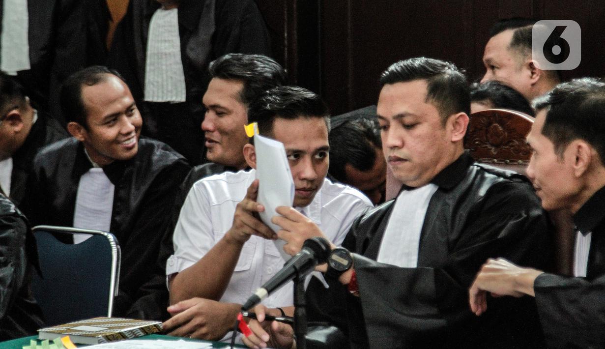 Terdakwa Richard Elieze berdiskusi dengan kuasa hukumnya disela sidang lanjutan pemeriksaan saksi kasus pembunuhan berencana Brigadir Yosua Hutabarat atau Brigadir J di Pengadilan Negeri Jakarta Selatan, Senin (7/11/2022). Richard Eliezer dan Ricky Rizal yang merupakan mantan ajudan Ferdy Sambo serta Kuat Ma'ruf, sopir keluarga Sambo duduk bersama di kursi terdakwa pada hari ini. (Liputan6.com/Johan Tallo)