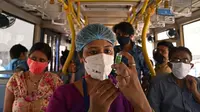Petugas kesehatan bersiap menyuntik pekerja dengan vaksin Covid-19 Covishield di dalam bus penumpang yang diubah menjadi pusat vaksinasi keliling di Kolkata, Kamis (3/6/2021). India telah menderita pandemi yang menghancurkan sejak April, dan baru-baru ini mulai mereda. (Dibyangshu SARKAR/AFP)