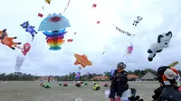 Peserta dari Malaysia menyaksikan layang-layangnya saat mengikuti festival layang-layang di Bali, Indonesia, (4/8). Festival ini diselenggarakan untuk mempromosikan pariwisata di pulau resor. (AP Photo/Firdia Lisnawati)