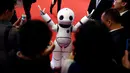 Para pengunjung melihat dan berinteraksi dengan Urobot Humanoid yang diproduksi oleh Xiao Yanlin di Konferensi Robot Dunia, WRC 2016 di Beijing, Tiongkok (21/10). Pameran robot kelas dunia ini berlangsung hingga 25 Oktober. (Reuters/Thomas Peter)