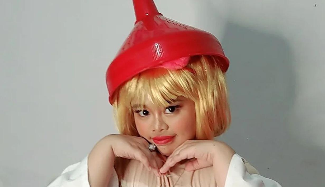 Kekeyi mempercantik penampilannya dengan bando merah mudah dengan aksesoris bola-bola bertektur bulu lembut. Ia juga membawa corong. Ini bikin netizen tak habis pikir. Menyertai unggahan ini, Kekeyi menulis status teks ringkas. “Keyon lagi cari air,” cuitnya seraya menyematkan emotikon wajah ngakak. Ratusan orang menyukai unggahan ini. (Foto: Dok. Instagram @rahmawatikekeyiputricantikka23)