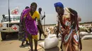 Warga membawa bahan makanan yang didistribusikan oleh ICRC di daerah yang dikuasai oposisi di Thonyor, Sudan, Selasa (11/4). UNHCR mengatakan Sudan Selatan, Nigeria, Somalia dan Yaman kini berada di ambang kelaparan. (AFP PHOTO / Albert Gonzalez Farran)