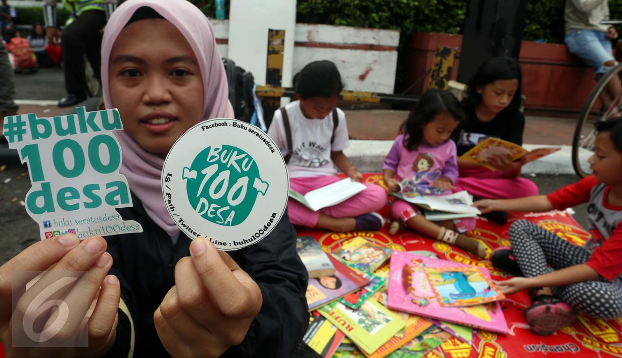 Seorang wanita memperlihatkan stiker saat kampanye "Budayakan Membaca dari Desa untuk Indonesia" saat berlangsungnya Hari Bebas Kendaraan Bermotor atau Car Free Day (CFD), Jakarta, Minggu (2/4). (Liputan6.com/Johan Tallo)