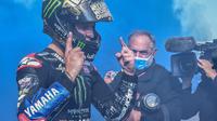Pembalap Yamaha, Fabio Quartararo, merayakan keberhasilan menjuarai MotoGP 2021 pada seri MotoGP Emilia-Romagna di Sirkuit Misano, Italia, Minggu (24/10/2021). (AFP/Andreas Solaro)
