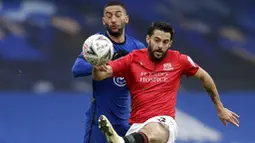 Pemain Chelsea, Hakim Ziyech, berebut bola dengan pemain Morecambe, Stephen Hendrie, pada laga Piala FA di Stadion Stamford Bridge, Minggu (10/1/2021). Chelsea menang dengan skor 4-0. (AP/Matt Dunham)