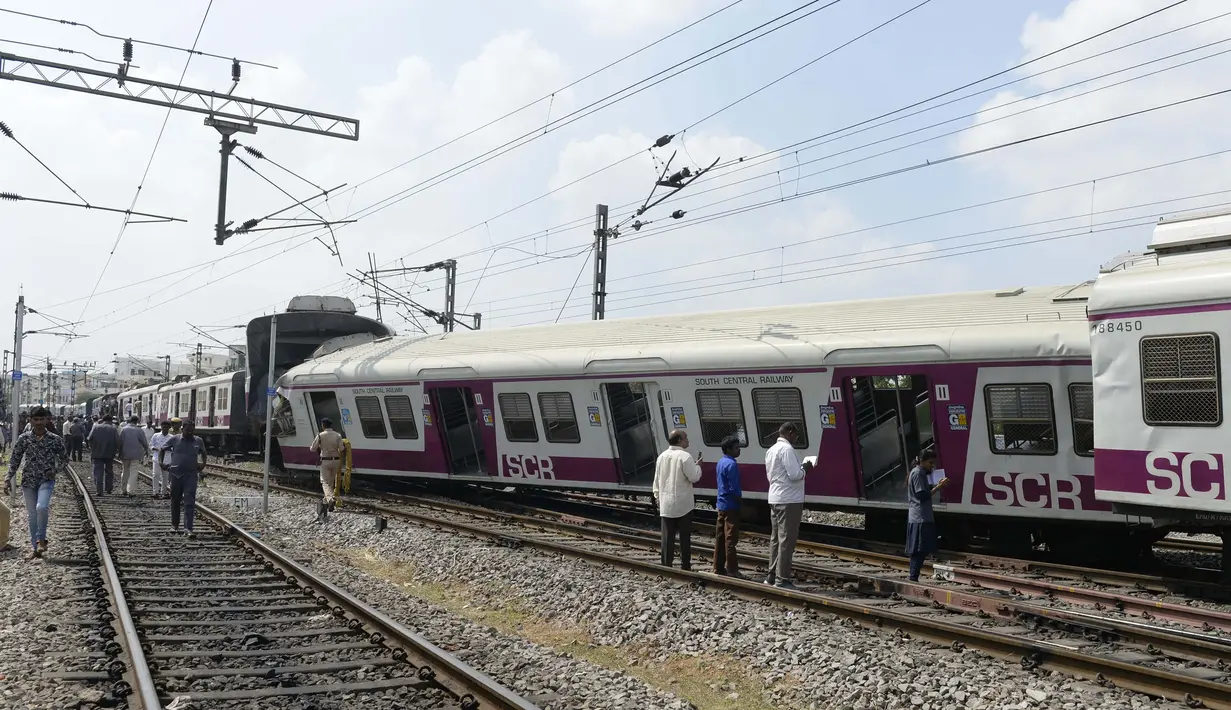 Sejumlah penumpang berdiri di samping gerbong kereta surburban yang bertabrakan dengan kereta ekspres antarkota di Stasiun Kereta Api Kachiguda di Hyderabad, India (11/9/2019). Sekitar 12 orang terluka akibat kecelakaan tersebut. (AFP Photo/Noah Seelam)