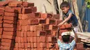 Dua orang anak mengangkat batu batu di sebuah bangunan New Delhi, India, Minggu (19/11). Anak-anak juga bekerja di malam hari, bekerja terlalu lama dan sebagian diperlakukan seperti budak. (DOMINIQUE FAGET)