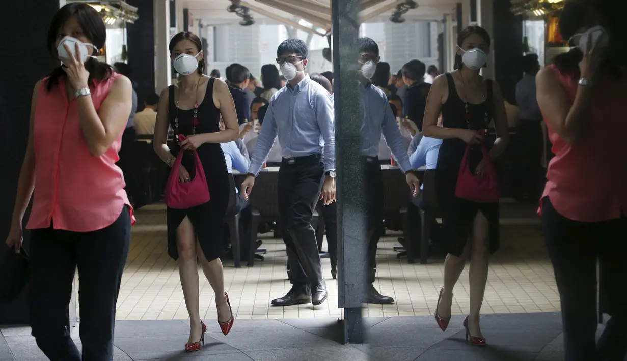 Warga Singapura menggunakan masker saat menjalankan aktivitas Singapura, Selasa (29/9/2015). Badan Lingkungan Hidup Nasional Singapura meningkatkan level kabut asap menjadi sangat tidak sehat (REUTERS/Edgar Su)