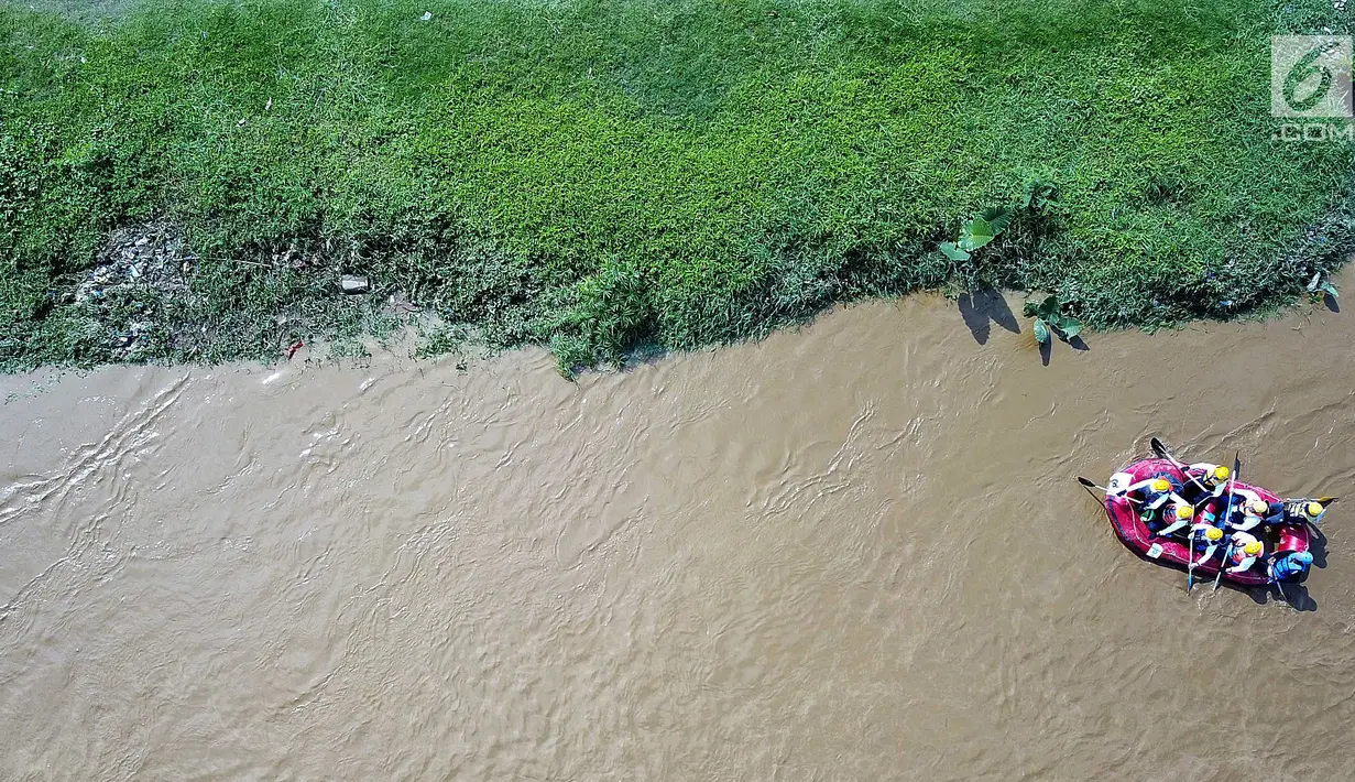 Peserta dengan perahu karet menyusuri Sungai Ciliwung sambil membersihkan sampah pada acara Bersih-Bersih Sungai Ciliwung, Jakarta, Minggu (08/4). Sebanyak 34 perahu karet dikerahkan menempuh perjalanan sepanjang 11 kilometer. (Liputan6.com/Fery Pradolo)