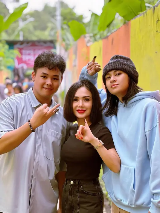 Gaya hot mom Yuni Shara coblosan bersama dua arjunanya. Yuni Shara tampil dengan outfit serba hitam, ia mengenakan kaus lengan pendek berwarna hitam dengan celana jeans yang juga berwarna hitam. Sedangkan kedua anak laki-lakinya kompak mengenakan outfit berwarna biru muda. [Foto: Instagram/yunishara36]