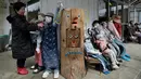 Tsukimi Ayano memeriksa boneka-boneka yang dipajang di luar bengkelnya di desa kecil Nagoro, Jepang, 16 Maret 2019. Tsukimi Ayano menempatkan boneka-boneka di jalanan, halte, sekolah, dan  tempat-tempat lainnya untuk menyuntikkan kehidupan ke desanya yang kekurangan penduduk. (KAZUHIRO NOGI/AFP)