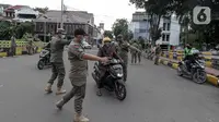 Petugas Satpol PP memberhentikan pengendara sepeda motor saat razia masker di kawasan Kota Tua, Jakarta, Kamis (24/2/2022). Perpanjangan PPKM level 3 Jabodetabek tertuang dalam Instruksi Menteri Dalam Negeri No. 12 Tahun 2022 tentang PPKM level 4, 3, 2 di Jawa dan Bali. (Liputan6.com/Faizal Fanani)