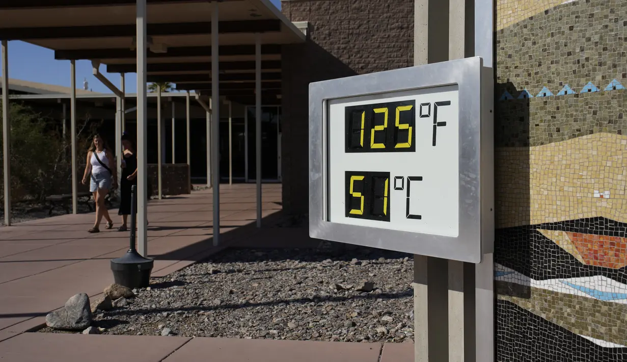 Orang-orang berjalan di dekat termometer di Pusat Pengunjung Furnace Creek, di Taman Nasional Death Valley, California, Kamis (1/9/2022). Termometer ini tidak resmi tetapi merupakan tempat foto yang populer. (AP Photo/John Locher)