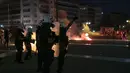 Polisi Yunani mengamankan area ketika pengunjuk rasa antivaksin melemparkan suar dan bom molotov selama rapat umum di alun-alun Syntagma, Athena tengah (24/7/2021). Aksi protes berlangsung ricuh usai beberapa pedemo melemparkan bom molotov ke arah polisi. (AP Photo/Yorgos Karahalis)