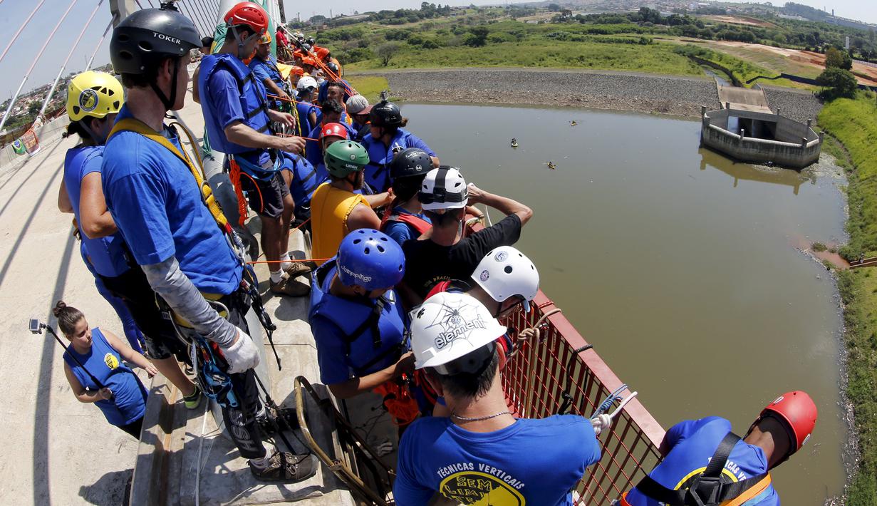 Sejumlah orang mempersiapkan diri untuk melompat dari atas jembatan dengan ketinggian 30 meter di Hortolandia, Brasil, Minggu (10/4). Sebanyak 149 orang mencoba membuat rekor dunia dengan melompat bersama dari atas jembatan. (REUTERS/Paulo Whitaker)