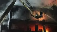 Petugas pemadam kebakaran berusaha memadamkan api di sebuah gedung berlantai empat, di New Delhi, India, Jumat, 13 Mei 2022. (Foto AP/Dinesh Joshi)