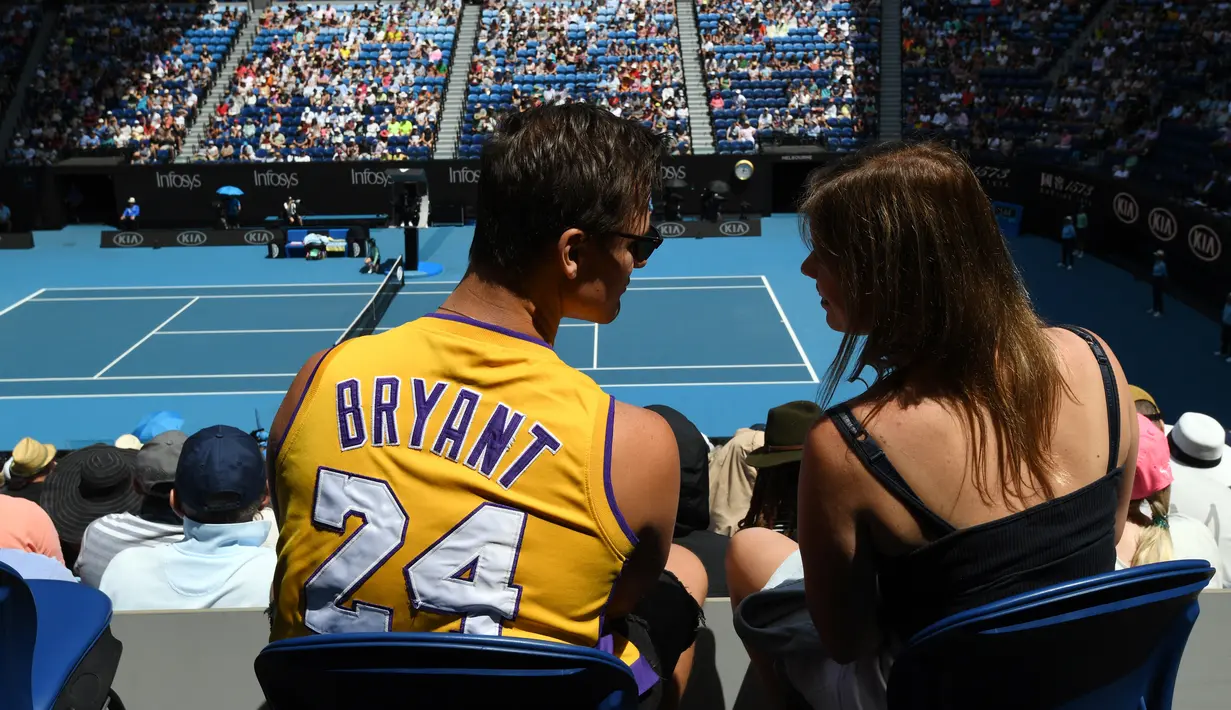 Seorang penonton mengenakan jersey basket Kobe Bryant saat menyaksikan pertandingan antara petenis Rumania, Simona Halep dengan Elise Mertens dari Belgia pada babak kedelapan Australia Terbuka 2020 di Melbourne, Senin (27/1/2020).  (Greg Wood/AFP)