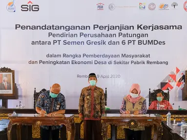 Dirut PT Semen Gresik, Mukhamad Saifudin (kiri), Direktur BUMDes PT Indo Kadiwono Sukses, Uswatun Khasanah (kanan) menandatangani Perjanjian Kerjasama Pendirian Perusahaan Patungan antara PT Semen Gresik dengan 6 PT BUMDes di Rembang, Kamis (9/4/2020). (Liputan6.com/Pool/SIG)