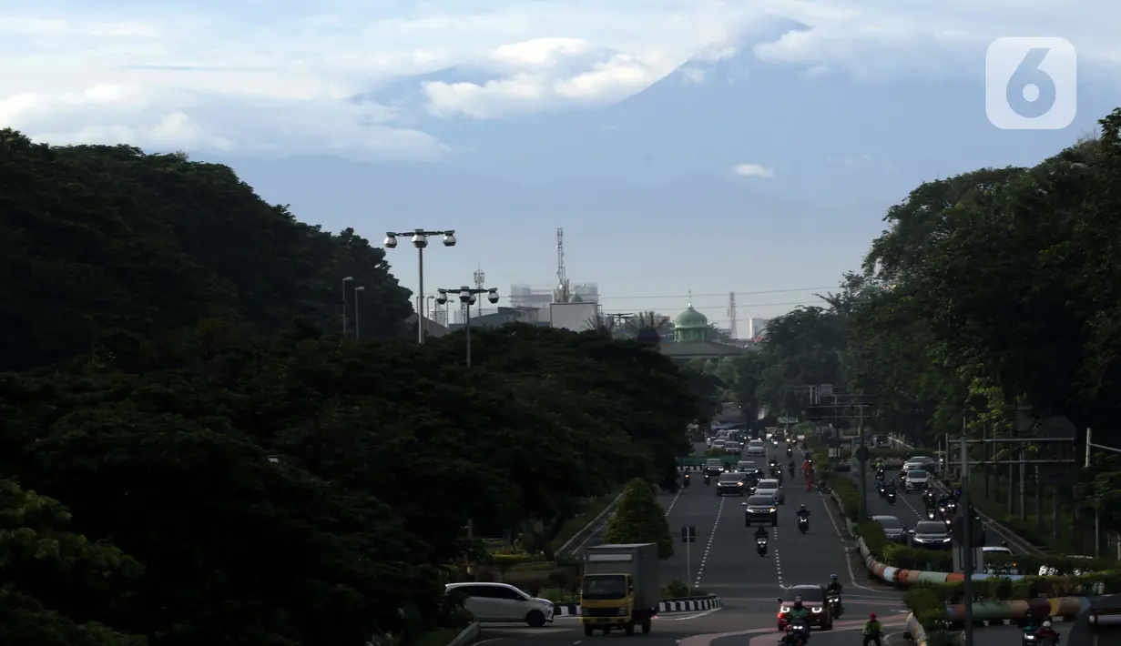 Kawasan gunung Gede-Pangrango terlihat samar menjadi latar belakang pemandangan di Jalan Benyamin Sueb, Kemayoran, Jakarta, Kamis (18/2/2021). Jika cuaca cerah, kawasan gunung Gede-Pangrango bisa terlihat dengan jelas dari atas jembatan layang Jalan HBR Motik. (Liputan6.com/Helmi Fithriansyah)