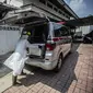 Petugas kesehatan menyiapkan peti mati berisi korban virus corona COVID-19 ke dalam ambulans di Bogor, Jawa Barat pada 3 Juli 2021. Angka kematian pasien Covid-19 saat isolasi mandiri di Indonesia sangat mengkhawatirkan di saat kasus semakin melonjak. (AFP/ Aditya Aji)